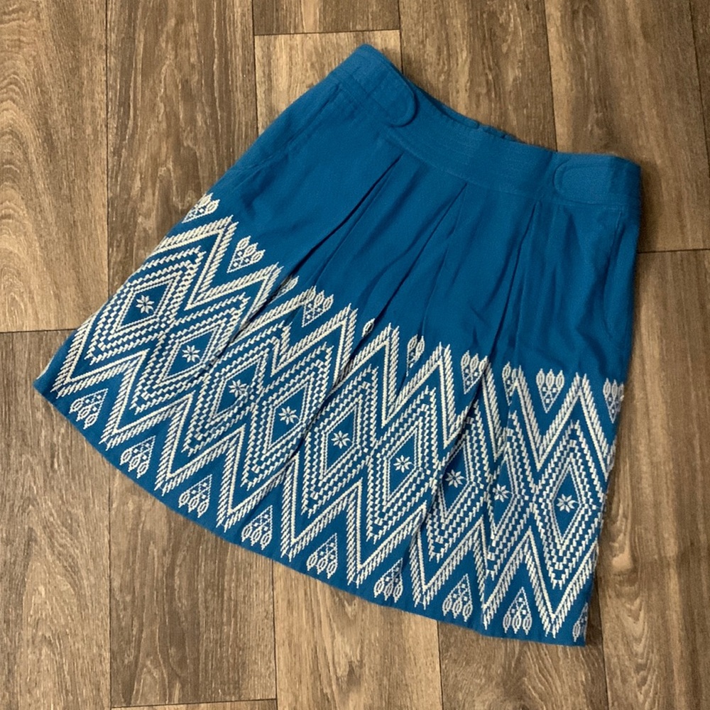 Blue pleated Anthropologie skirt with white embroidery